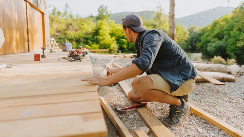 Man constructing a wooden deck