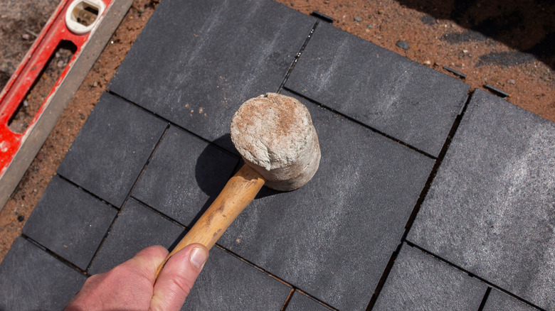 Person laying down rubber paver tiles
