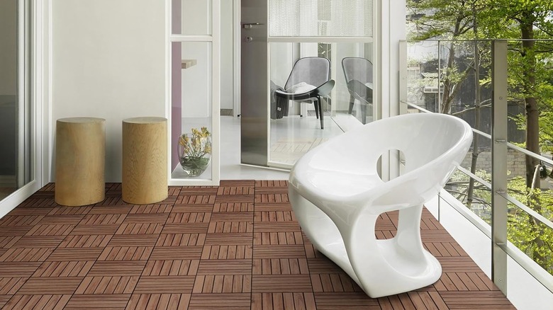 Yaheetech deck tiles on a large balcony with modern patio furniture and a forest in the background.