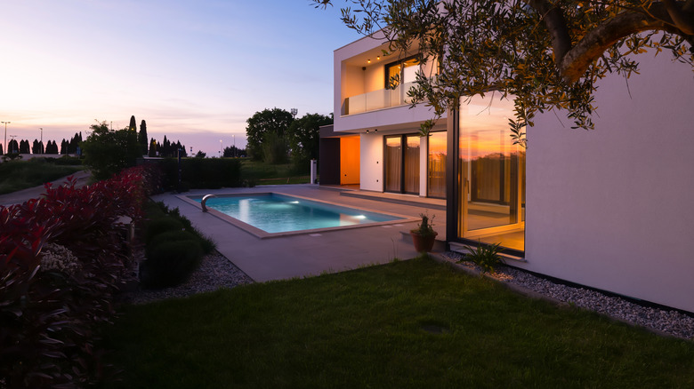 Modern luxury villa with a luminous swimming pool at twilight