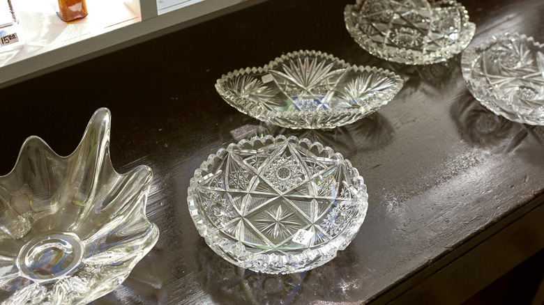 Vintage pressed glass dishes sit on a window ledge.