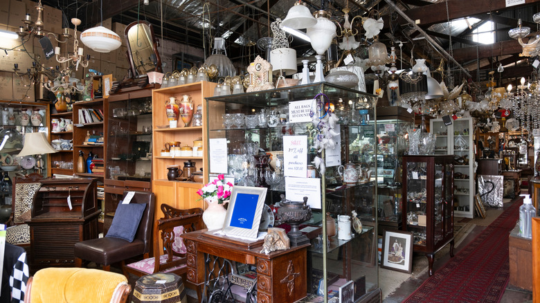 Shelves of vintage glassware and other items at a thrift store.
