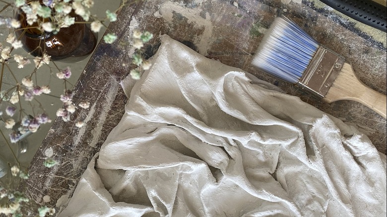 Textured fabric canvas painted white with paintbrush and flowers