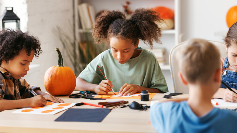 A group of children gathered around a table crafting
