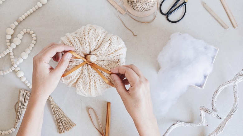 Hobby background with handmade knit pumpkins, tools, and accessories.