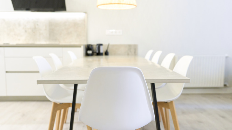 Empty off-white dining table with white chairs
