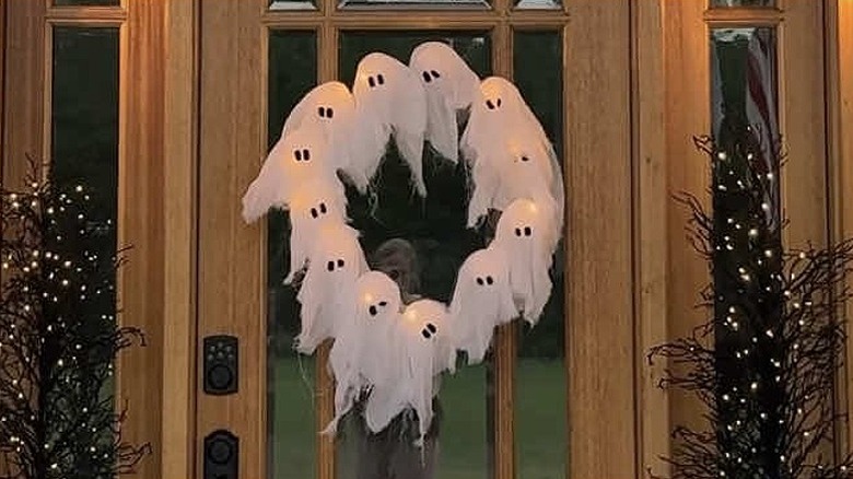 A spooky ghost wreath hanging on a door