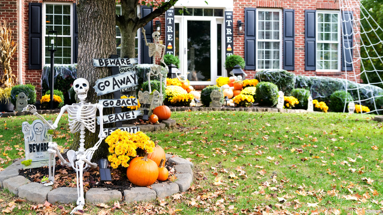 The front yard of a brick home is elaborately decorated for Halloween