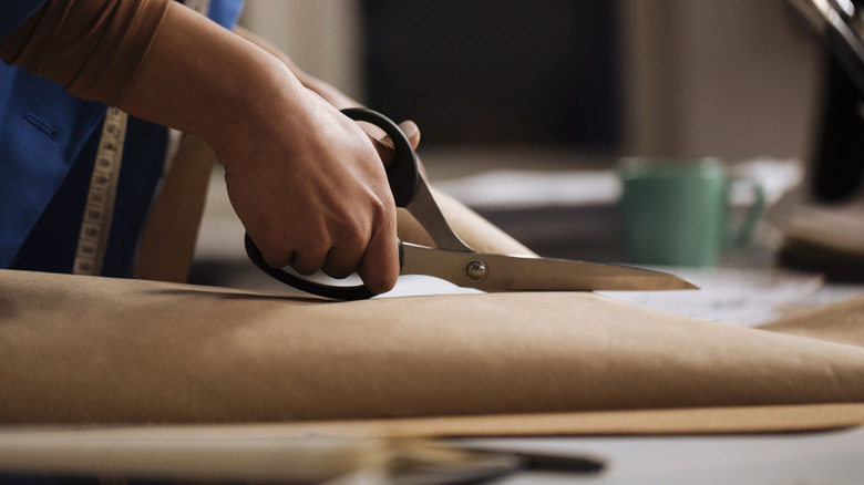 A person cuts fabric with scissors