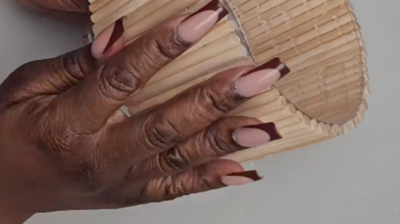 Hands holding a Dollar Tree trifle bowl decorated with dowels