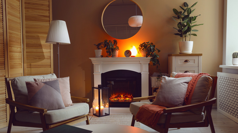 A cozy living room with a real fireplaces, ambient lighting, and a couple of sofas