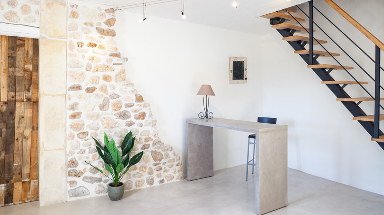 partial stone wall in small space with cement desk in front