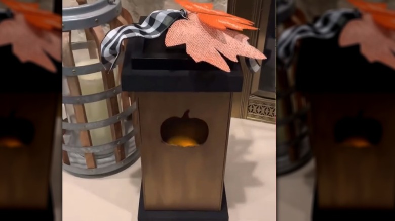 A finished product of a DIY fall-inspired lantern with a pumpkin cut out