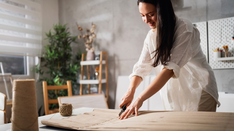 Person cutting cardboard on a table