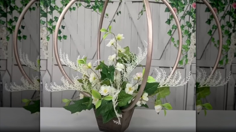 hula hoops sprayed in gold and a beautiful arrangement of plastic flowers
