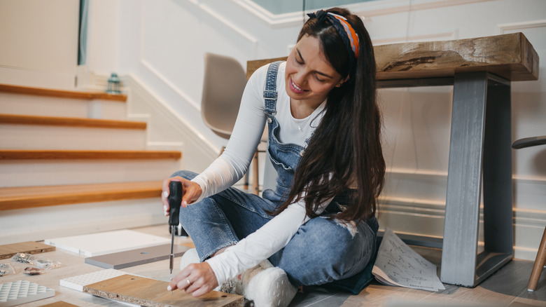 woman building furniture in home