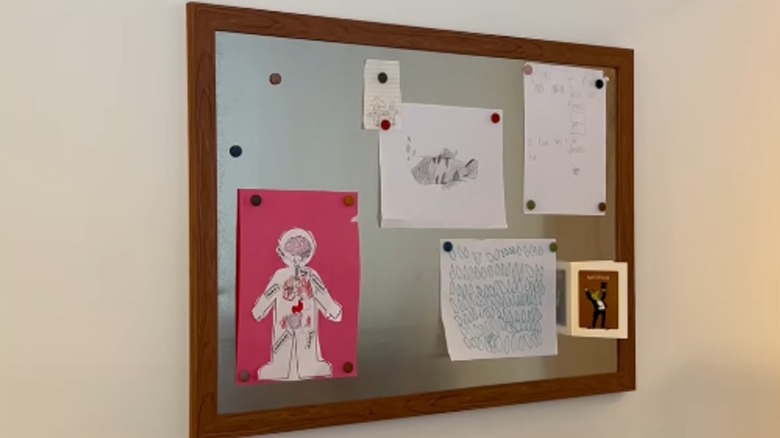 A DIY framed stainless steel sheet holds magnets and notes.
