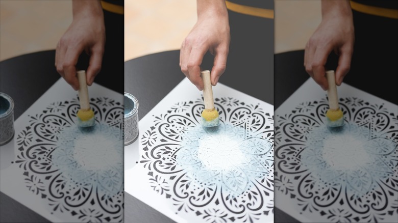 Hand stenciling a flower design