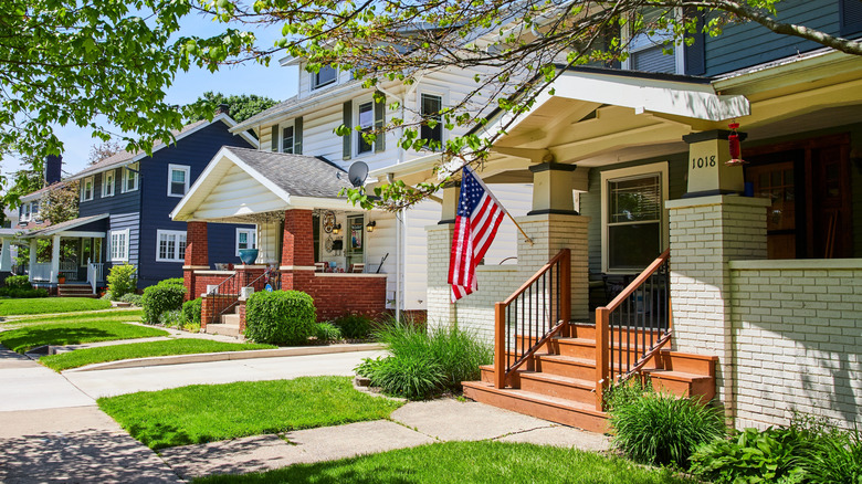 Charming white house with American flag and freshly cut lawn