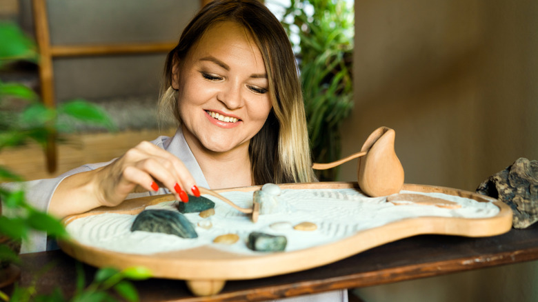 A woman arranging elements of her mini zen garden