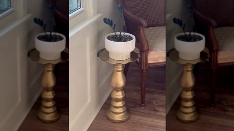 Plant stand made with thrifted candle holder and plate, painted gold.