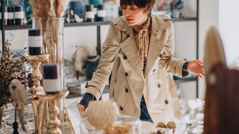 Woman shopping for candles and candle holders at a secondhand shop.