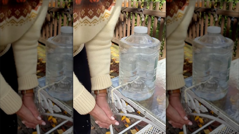 a person washing their hands at a DIY outdoor hand-washing station