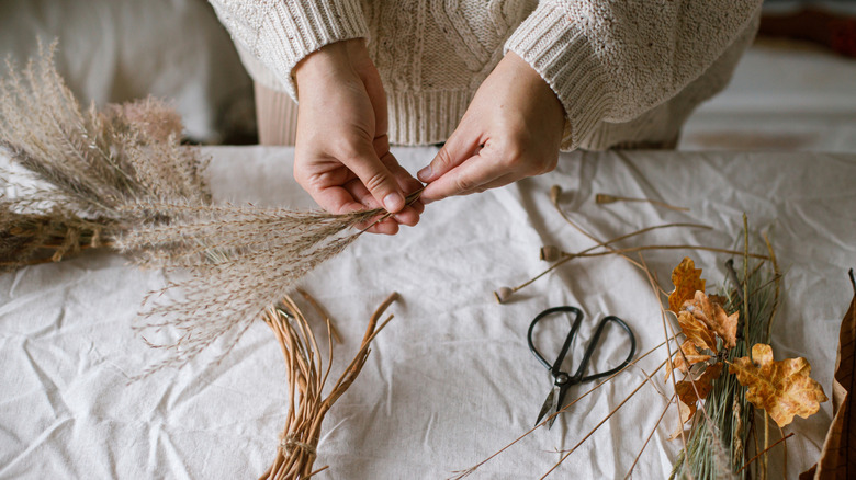 Person doing a DIY with faux autumn plants