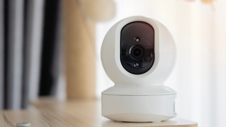 A wireless security camera placed on a wooden table