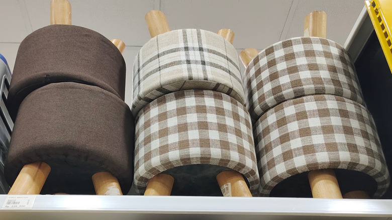 Brown, plaid, and gingham upholstered stools on a store shelf