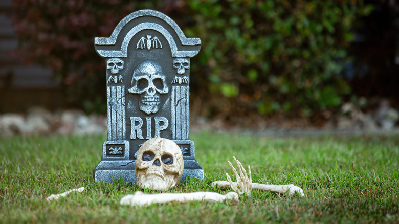 A tombstone decor with skull and bones in front