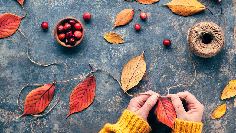 Hands making a leaf garland