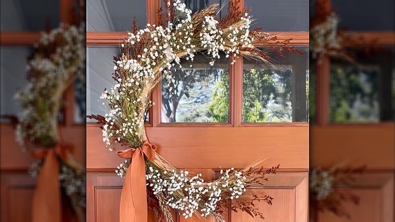 A gorgeous crescent moon wreath hung on a timber front door