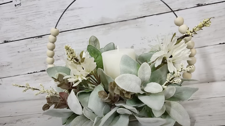 A floral candleholder embellished with a Dollar Tree wooden bead wreath.