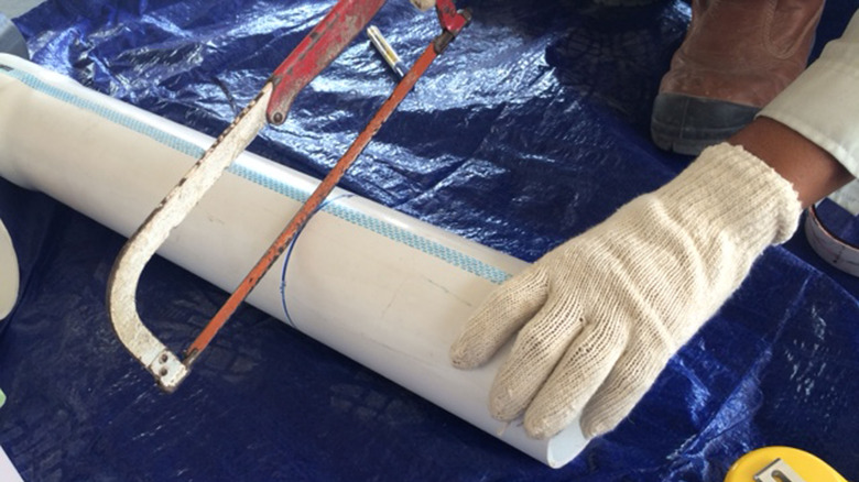 Person cutting PVC pipe