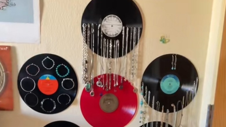 Vinyl record jewelry holders hanging on the wall behind a door