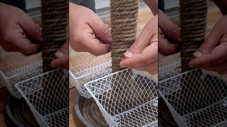 Man making DIY storage basket using toilet paper holder and twine