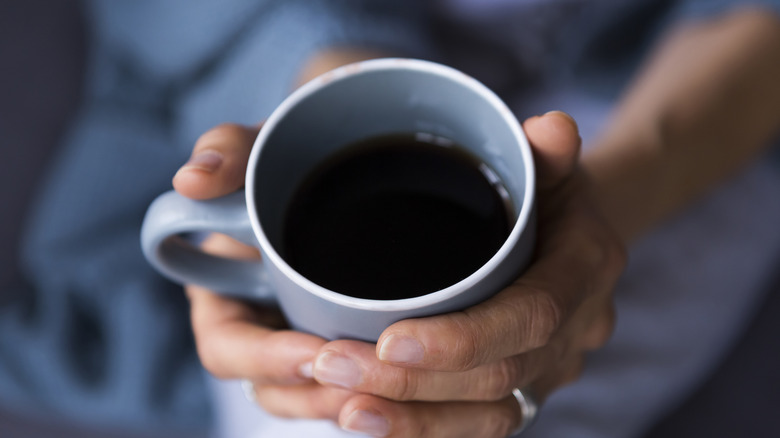 A woman holding a cup of coffee