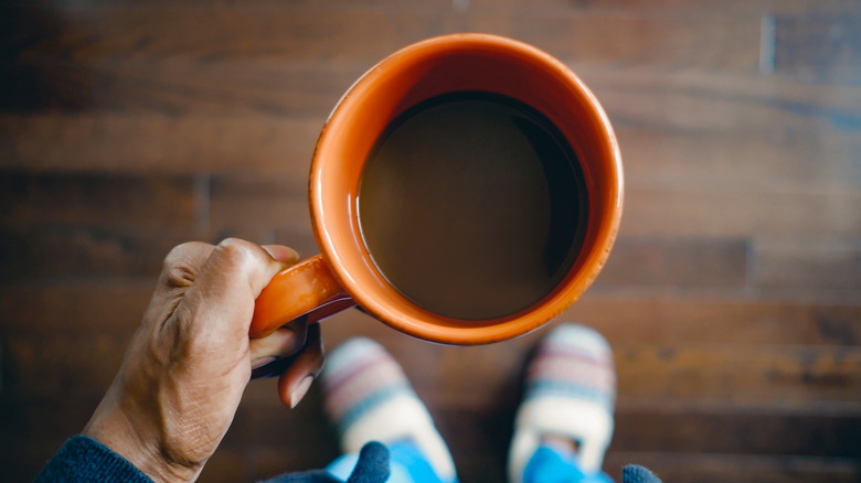 Someone holding a mug with coffee