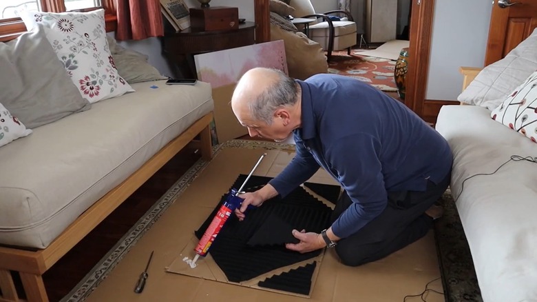 Man gluing acoustic panels to cardboard