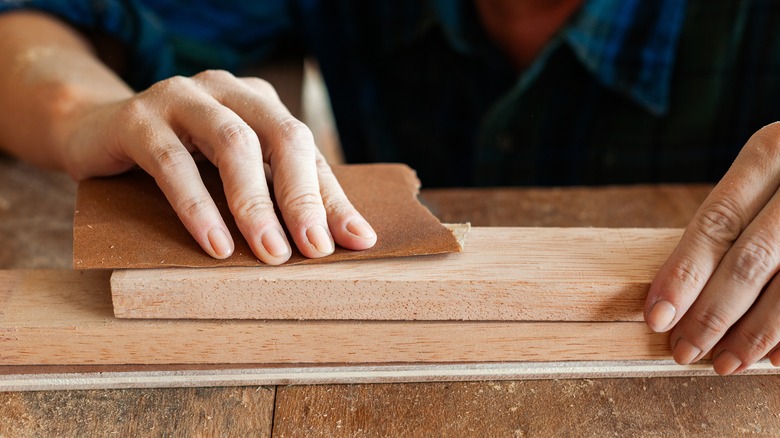 person sanding wood diy