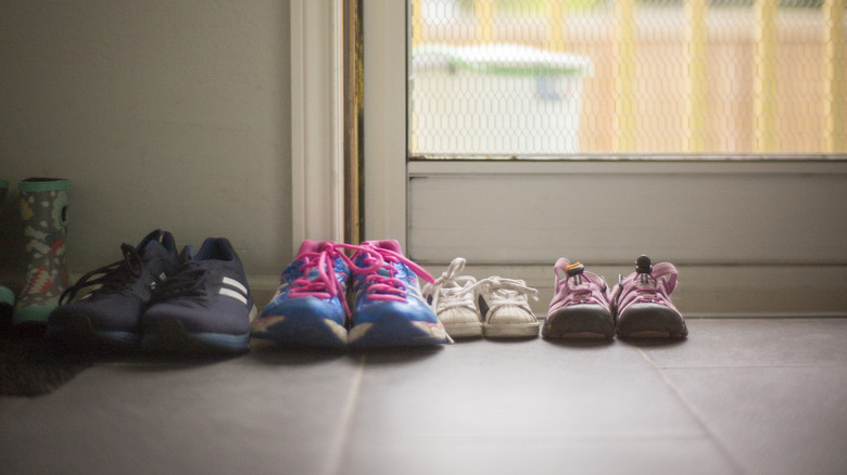 A bunch of shoes sitting at an entryway
