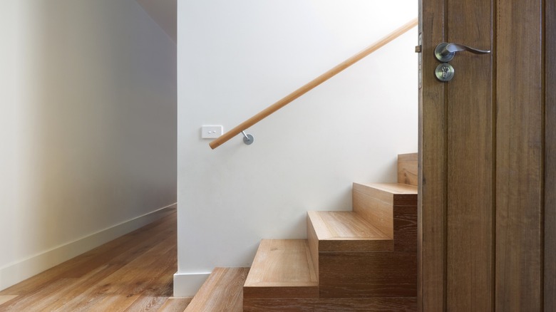 A modern wood staircase with a wood banister