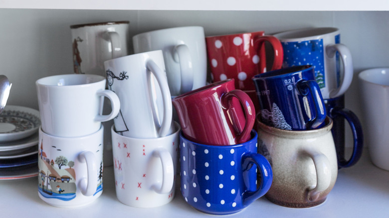 stacked mugs inside kitchen cabinet