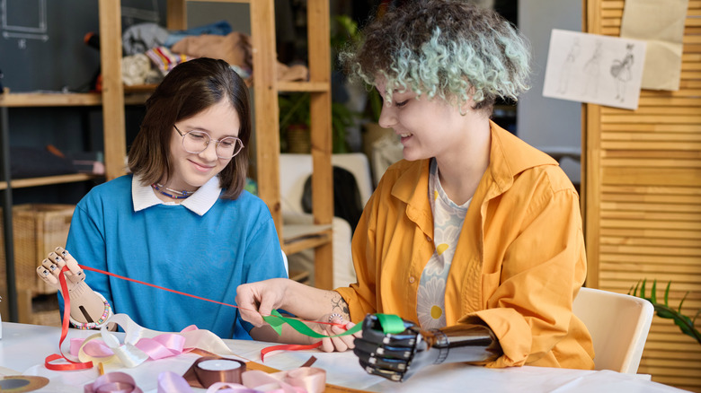 two teenagers crafting with ribbon