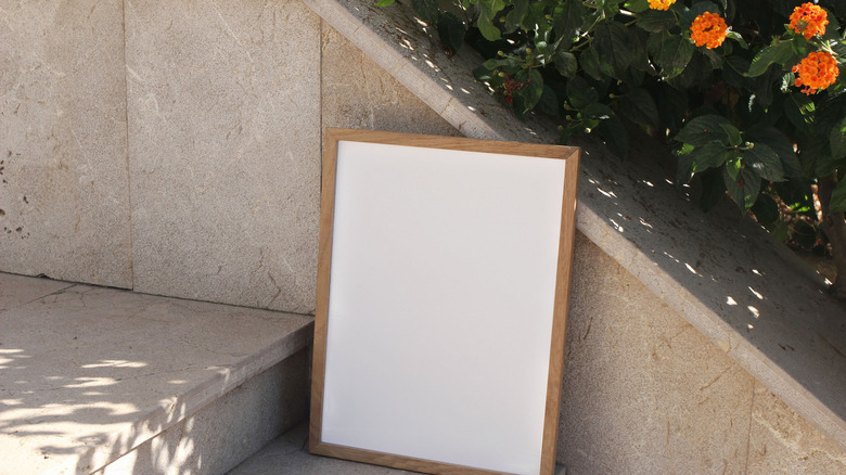 Wooden picture frame leaning against stone wall