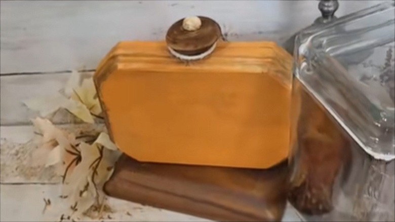 A rustic wood pumpkin made from Dollar Tree supplies decorates a table.