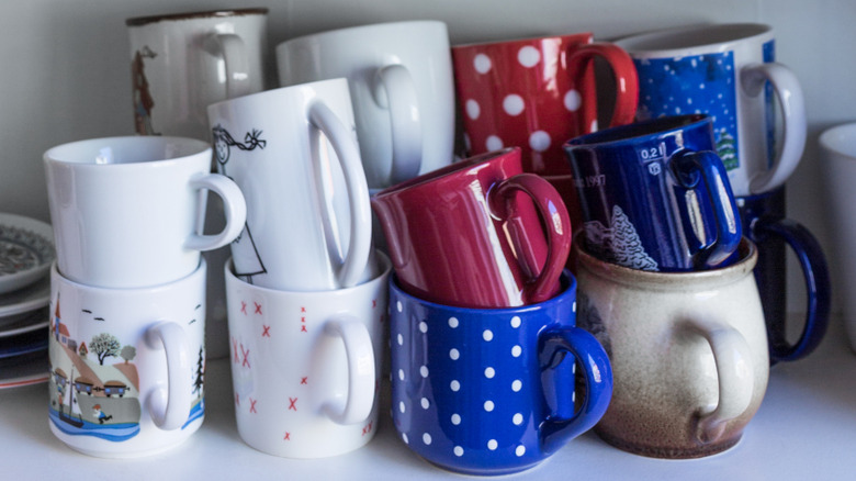 Pile of coffee mugs in kitchen cabinet