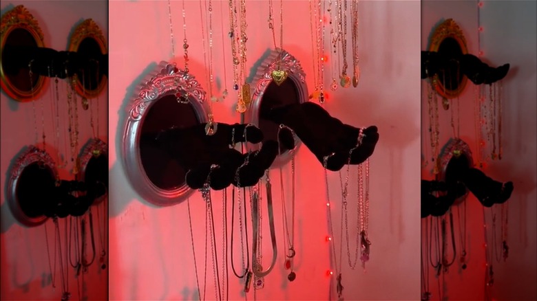 framed hands holding necklaces