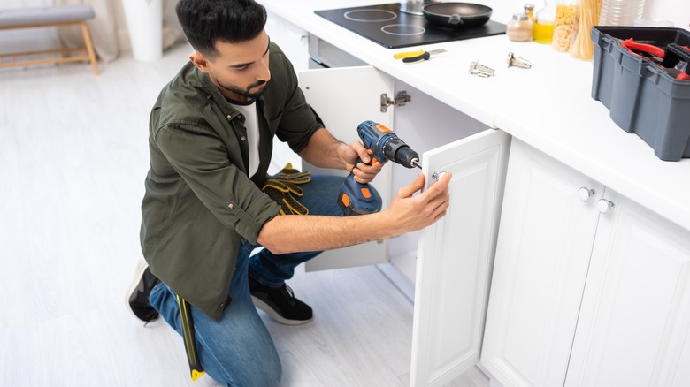 person changing cabinet hardware